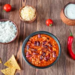 chili con carne med ris, creme fraiche, revet ost og nachos