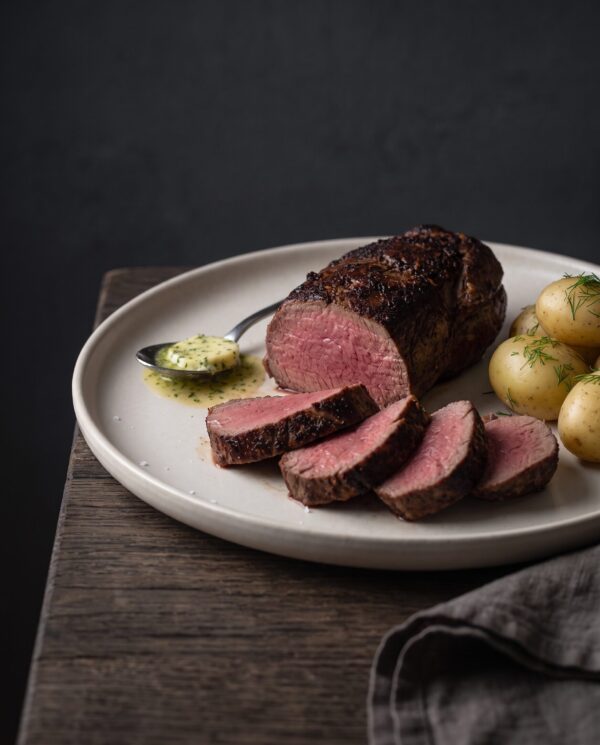 Stegt mørbrad af dansk krondyr skåret i medaljoner med rosa midte, serveret med nye kartofler, dild og kryddersmør.