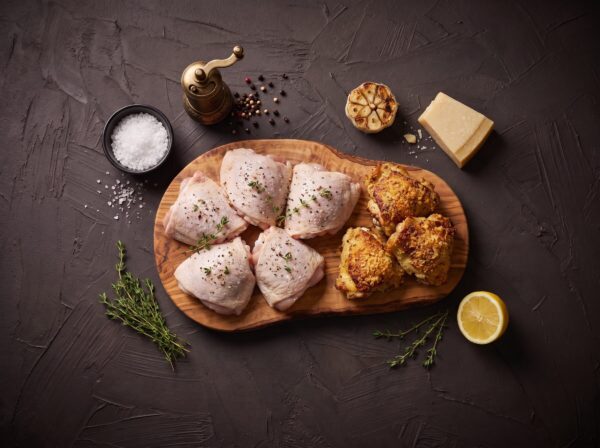 Rå økologiske kyllingeoverlår med parmesan og timian på træbræt