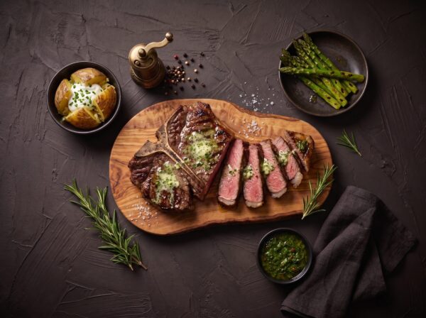 T-bone bøf skåret ud med kryddersmør, bagt kartoffel og asparges