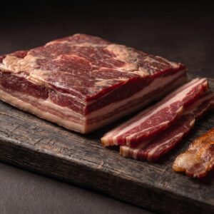 Oksebacon af skotsk højlandskvæg i ét stykke med rå skiver og sprødstegt bacon i kanten